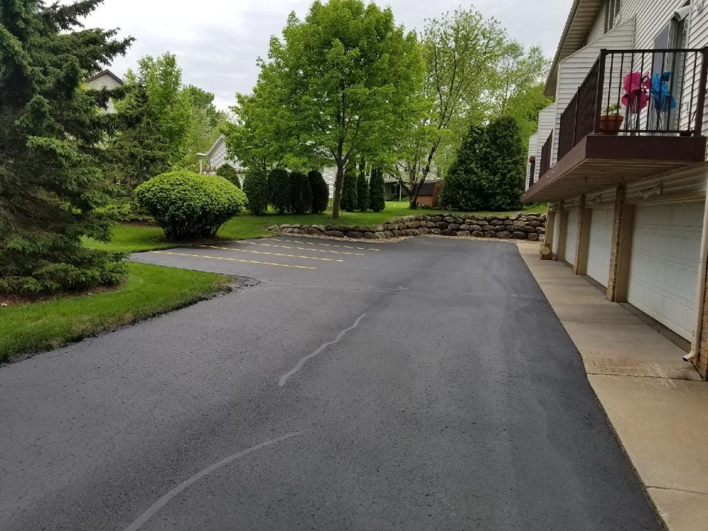 Parking lot crack filling and sealcoating with yellow line striping
