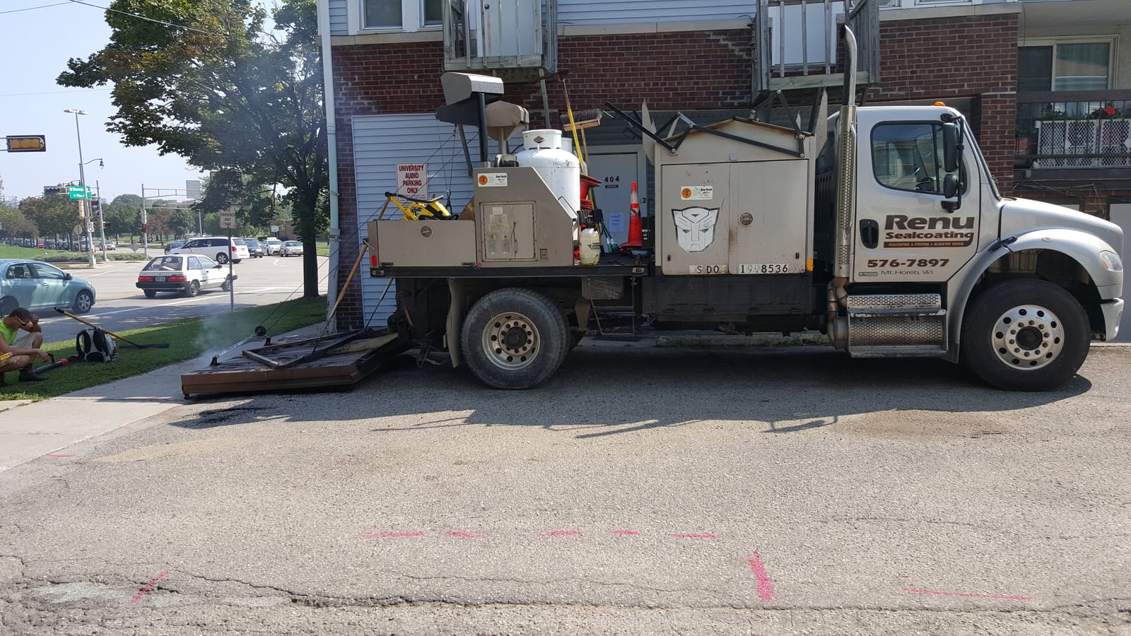 Renu Sealcoating's specialized asphalt repair truck on a Madison, WI job site