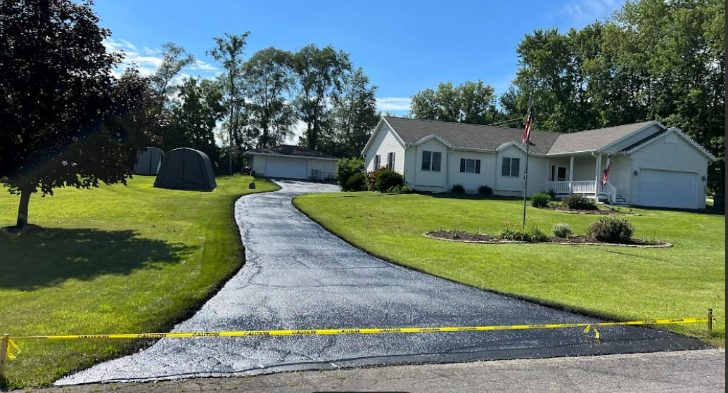 Long residential driveway sealcoating with fresh black finish in Madison, WI