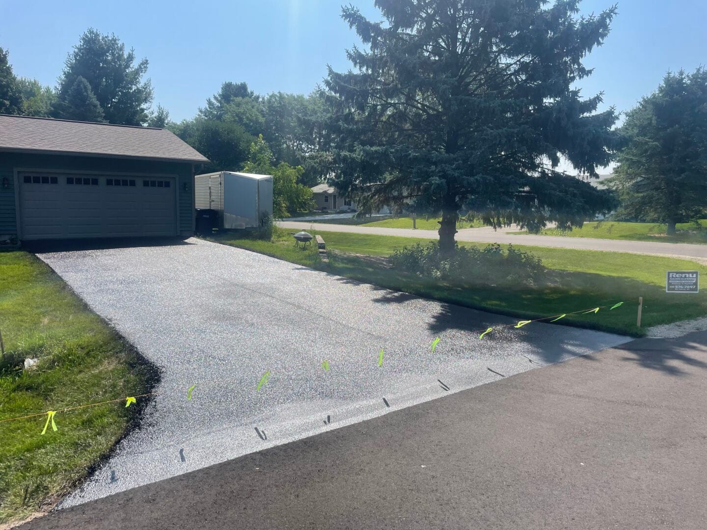 Freshly sealcoated driveway next to garage in Madison, WI