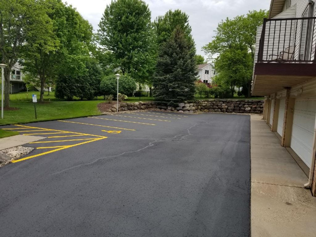 Small parking lot with fresh sealcoating and yellow striping in Madison, WI